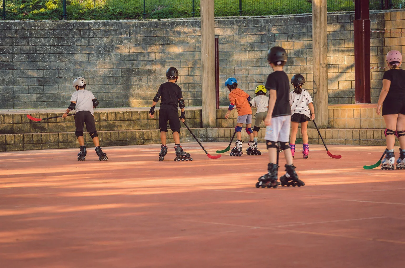 Haur talde bat kaskoekin eta patinekin ikastolako kirol-pistan